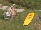 [Two old ladies beside a 'Surf Rescue' board]